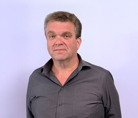 Portraitfoto eines Mannes mit grauem Hemd